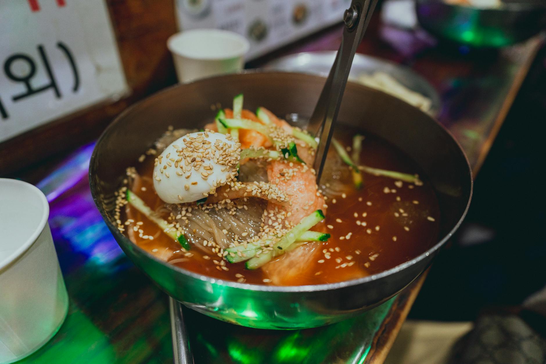 Bowl of fresh Korean kalguksu knife-cut noodles at a market kitchen