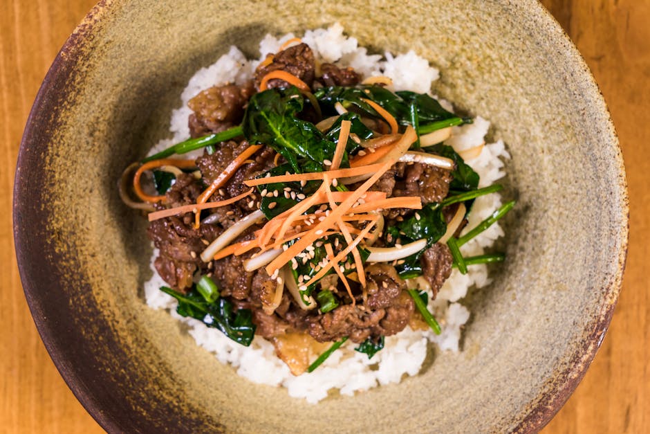 Korean rice bowl on table eaten with metal spoon