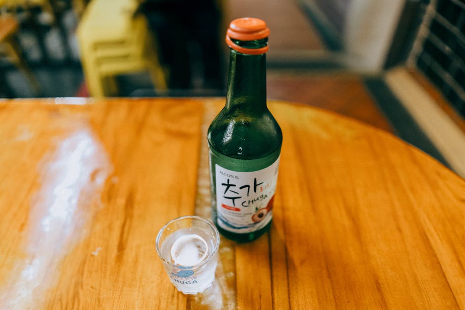 Korean soju being poured with two hands during a meal