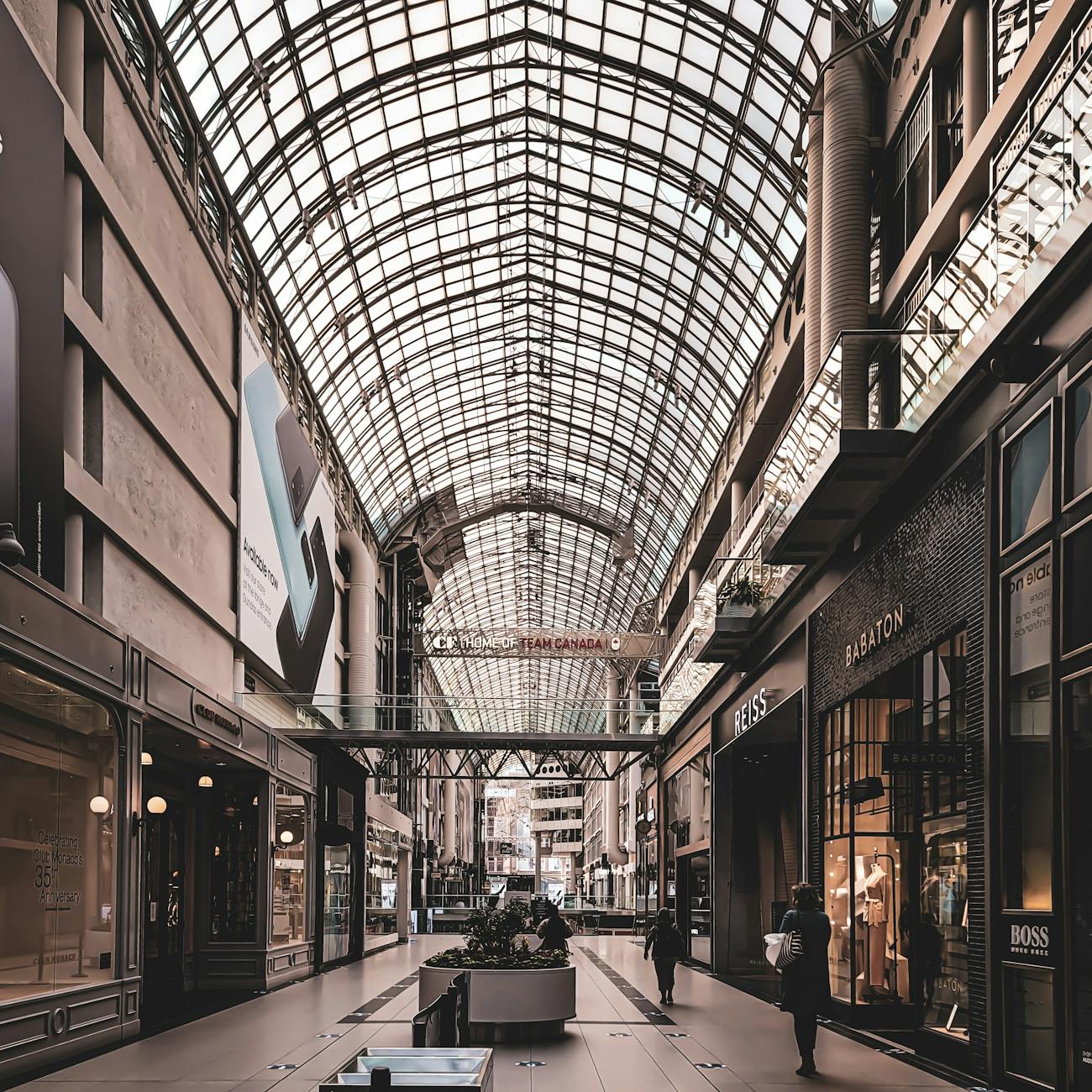 Modern luxury shopping mall interior with escalators and designer stores