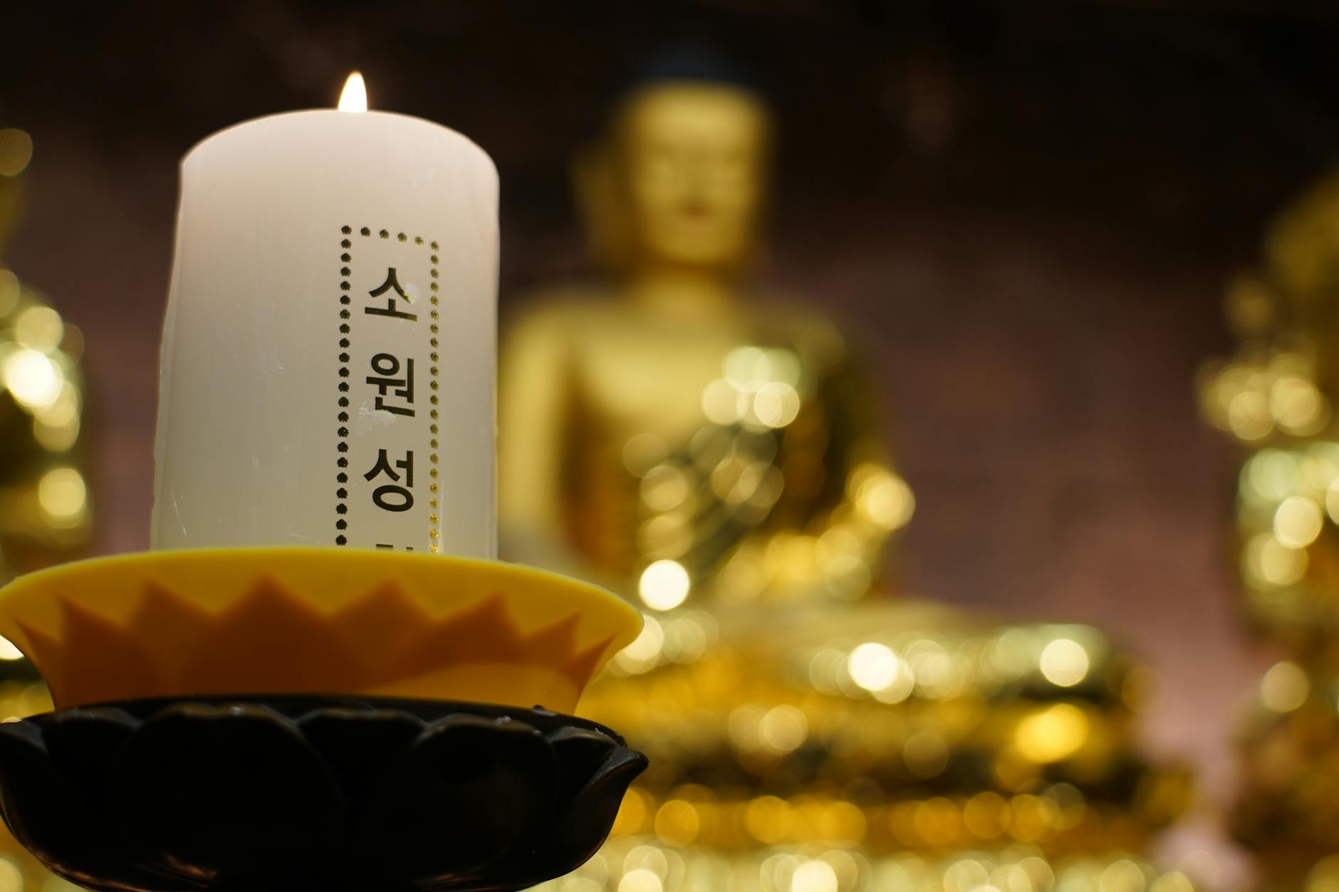 Golden Buddha statue and candle at a Seoul Buddhist temple for meditation wellness
