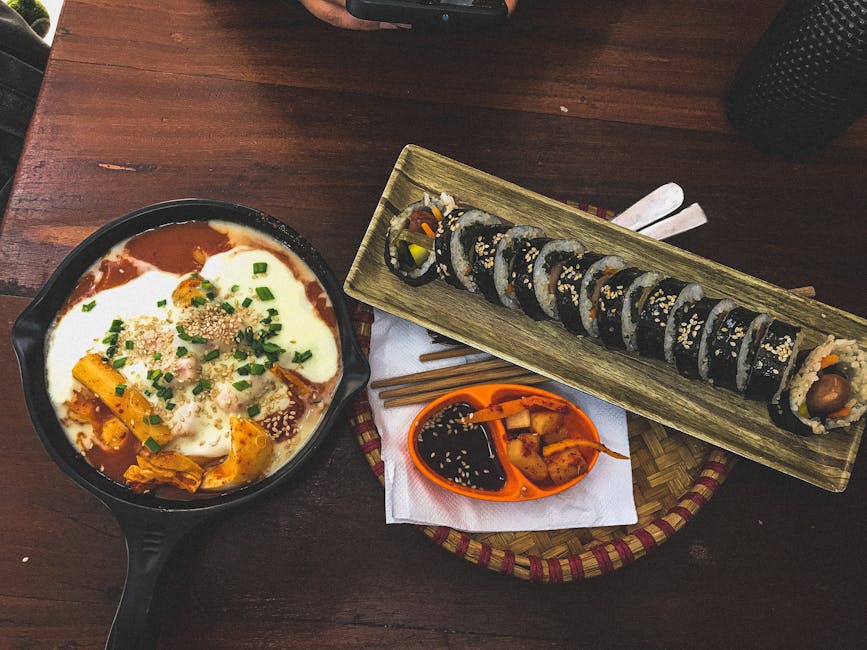 Top view of cheap Seoul Korean dishes including kimbap and spicy tteokbokki