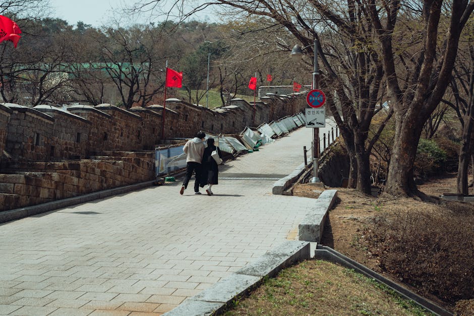 Couple walking along the Suwon Hwaseong Fortress wall path decorated with red lanterns