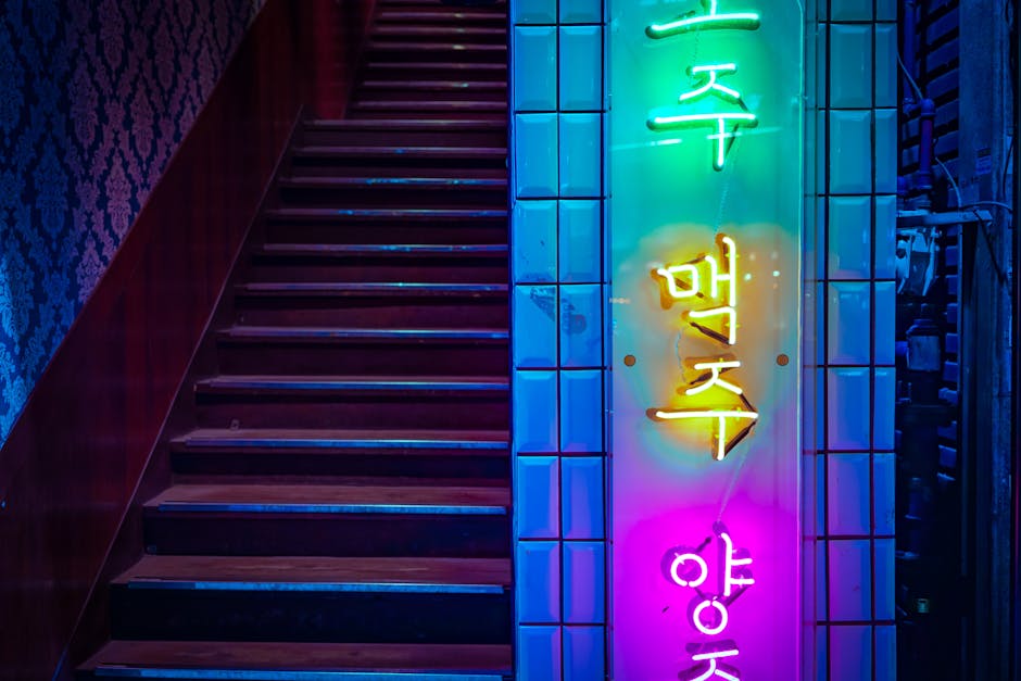 Colorful neon sign on a staircase in Seoul leading to karaoke rooms
