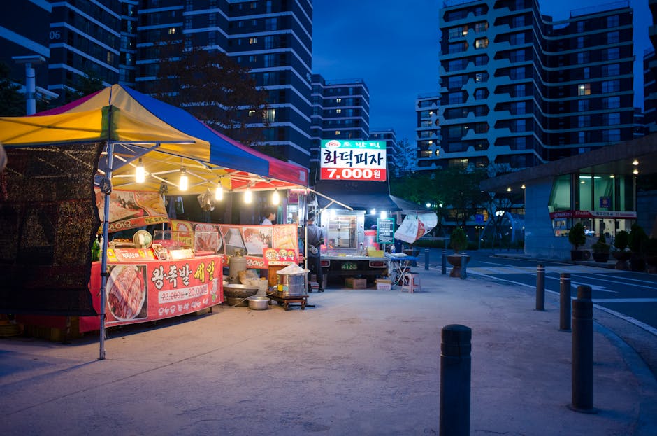 Outdoor Seoul street food stall at night with urban cityscape backdrop