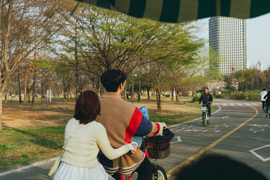 Couple cycling in vibrant Seoul park during springtime