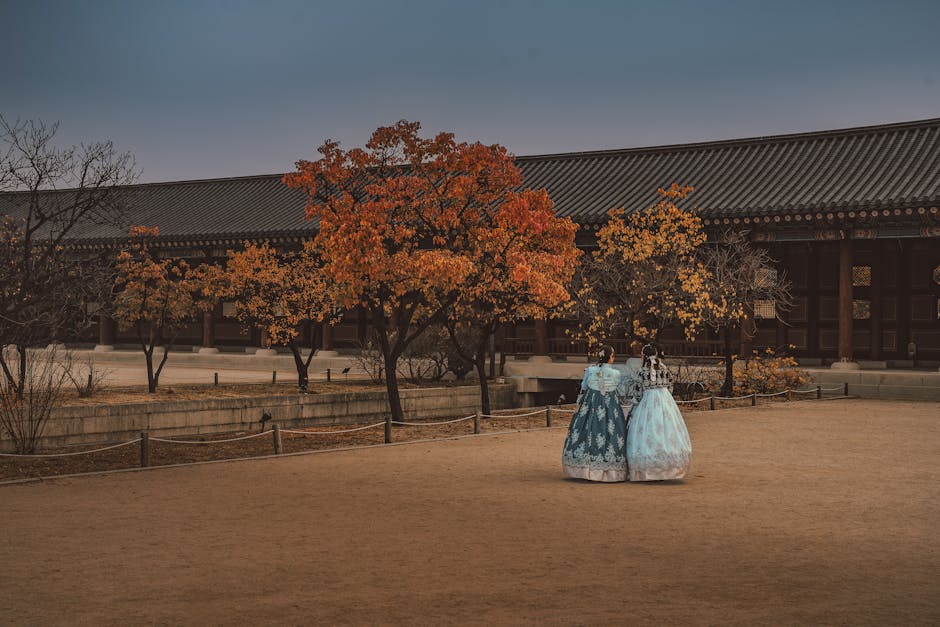 Two women in hanbok strolling Gyeongbokgung Palace autumn romantic