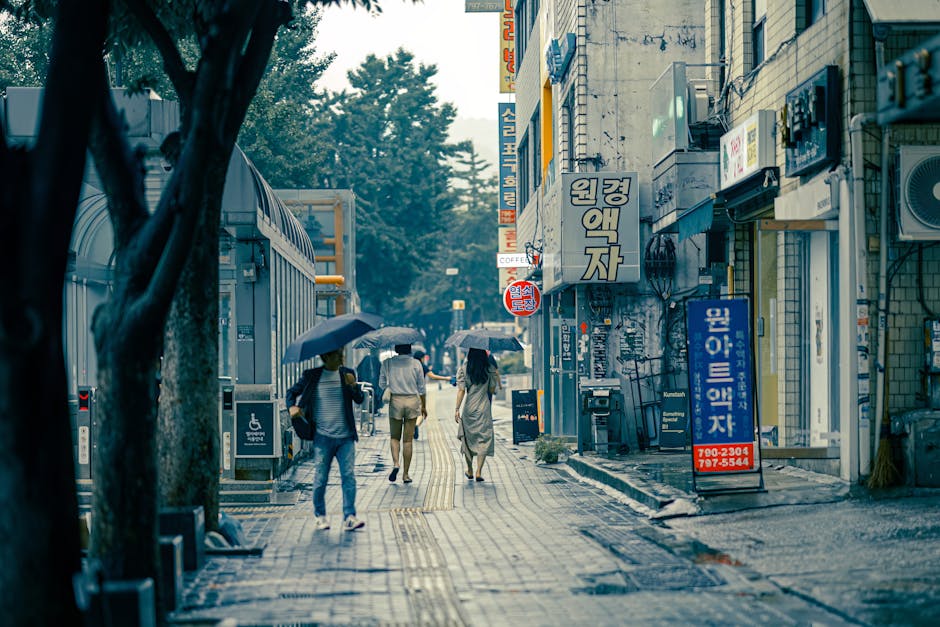 People walking with umbrellas on a rainy day in Seoul urban cityscape