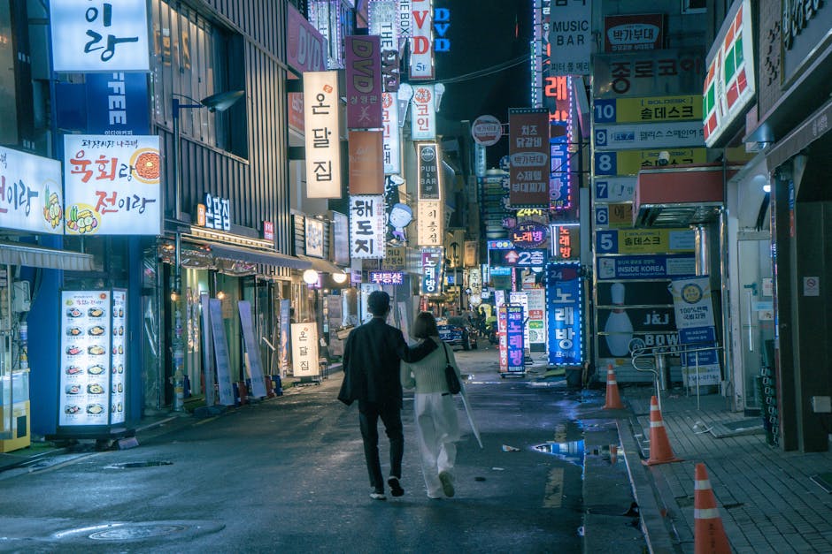 Couple walking through neon-lit streets of Itaewon Yongsan at night