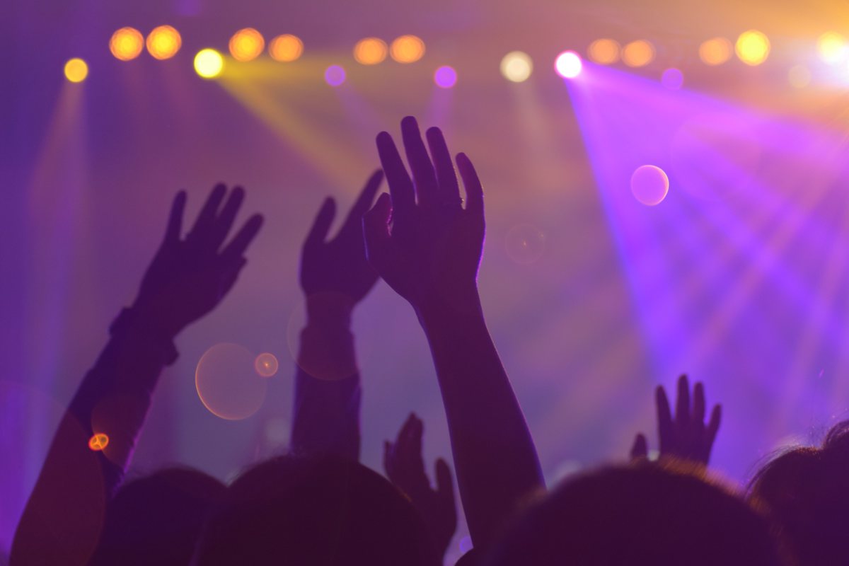 Crowd with hands raised on a packed Seoul nightclub dance floor under strobe lights