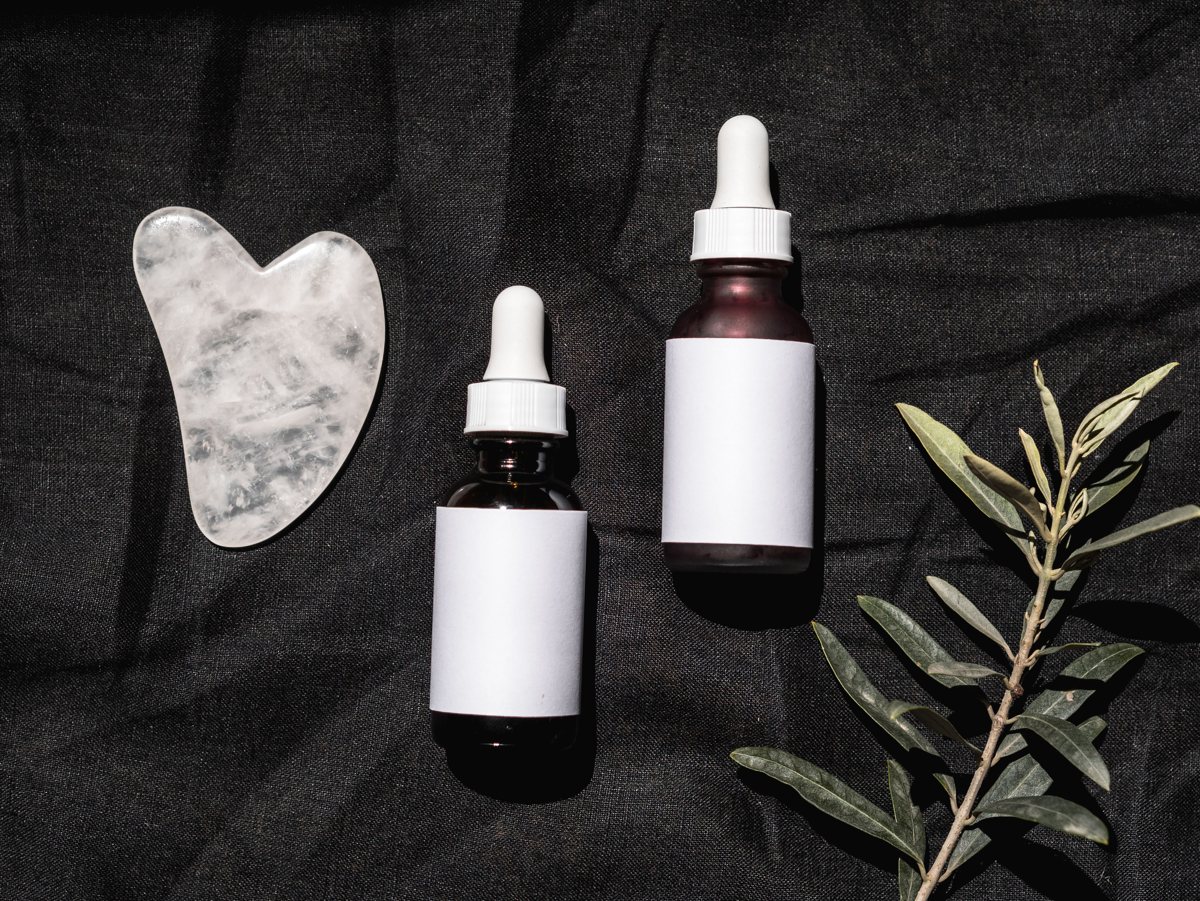 Flatlay of Korean skincare serums, toners and creams on a pink surface