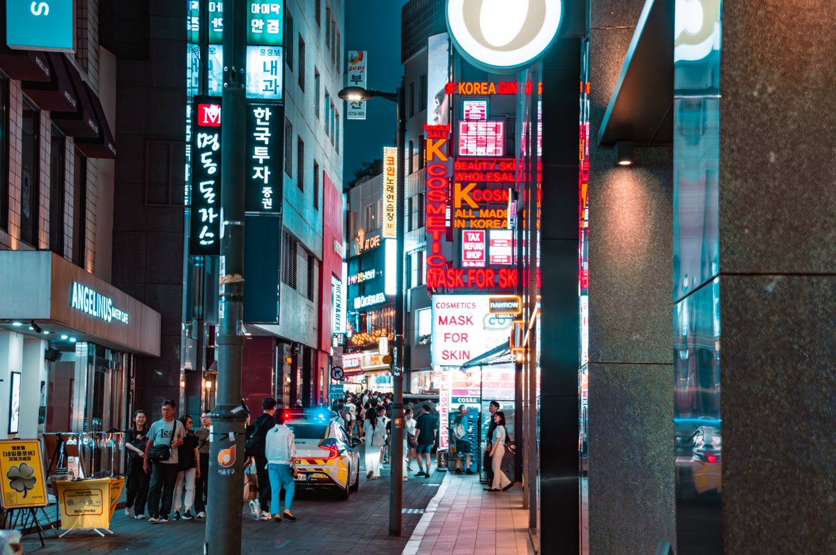 Shoppers walking Myeongdong's neon-lit shopping street in Seoul at night