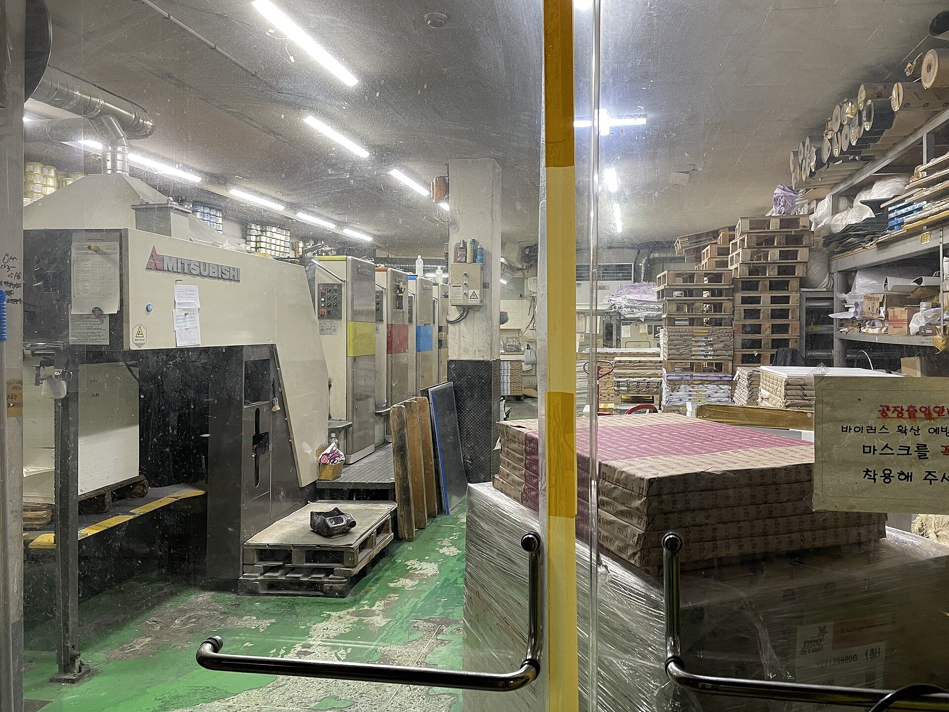 Interior of a small printing works in Euljiro with an offset press and stacked paper