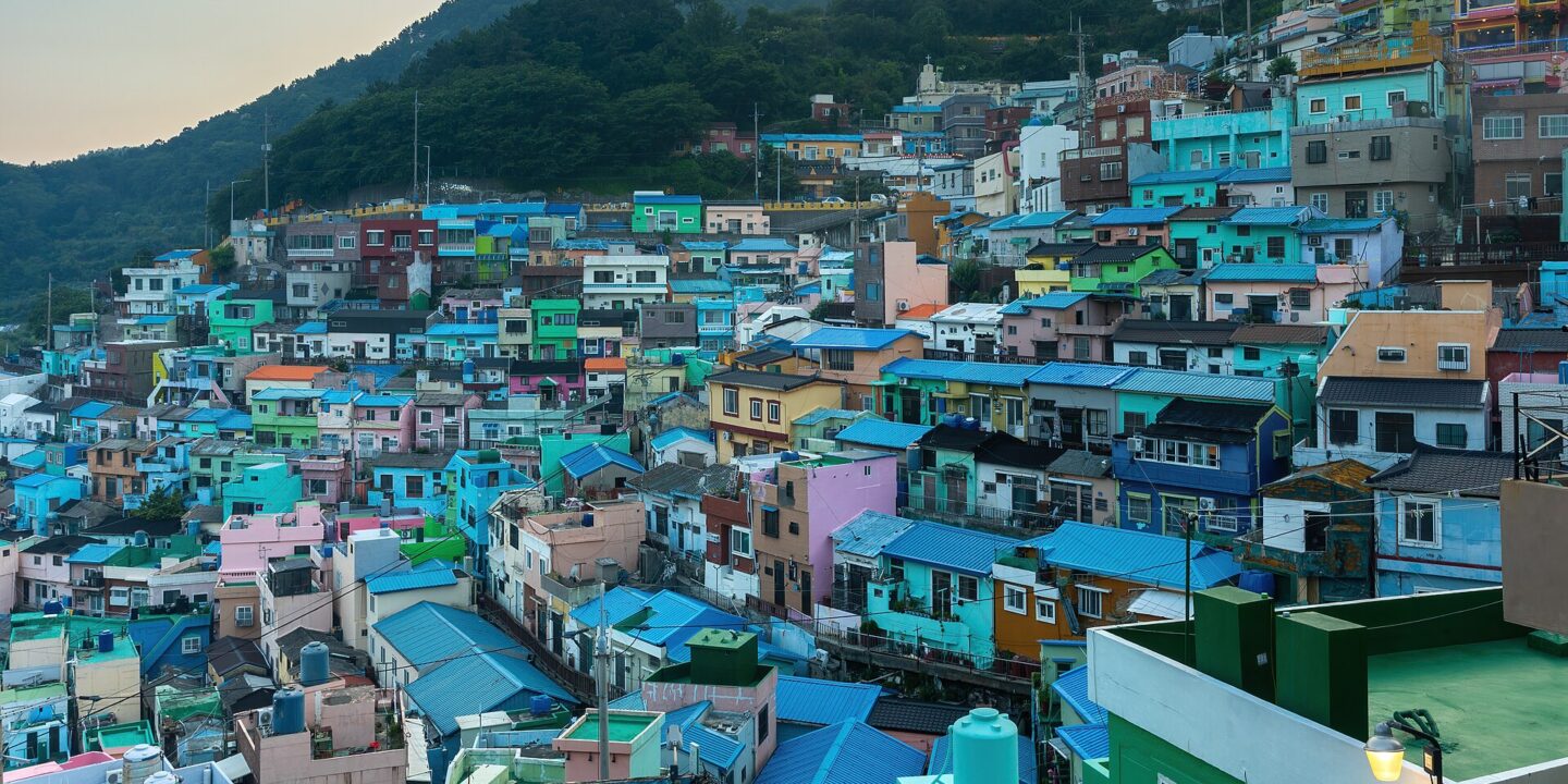 Brightly painted houses stacked up a hillside at Gamcheon Culture Village in Busan at sunset