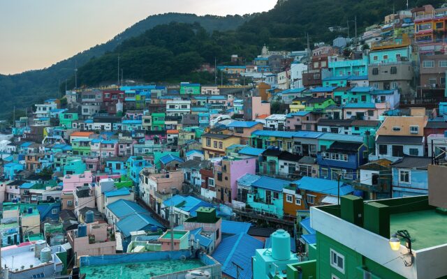 Brightly painted houses stacked up a hillside at Gamcheon Culture Village in Busan at sunset
