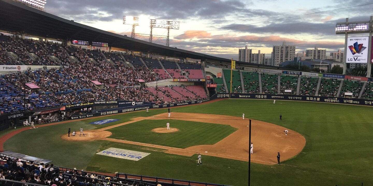 Jamsil Baseball Stadium in Seoul at dusk with a full crowd and a game in progress