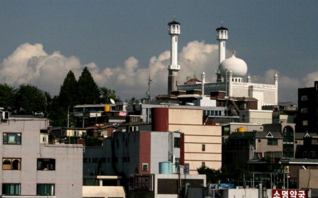 The white dome and twin minarets of Seoul Central Mosque rising above Itaewon rooftops