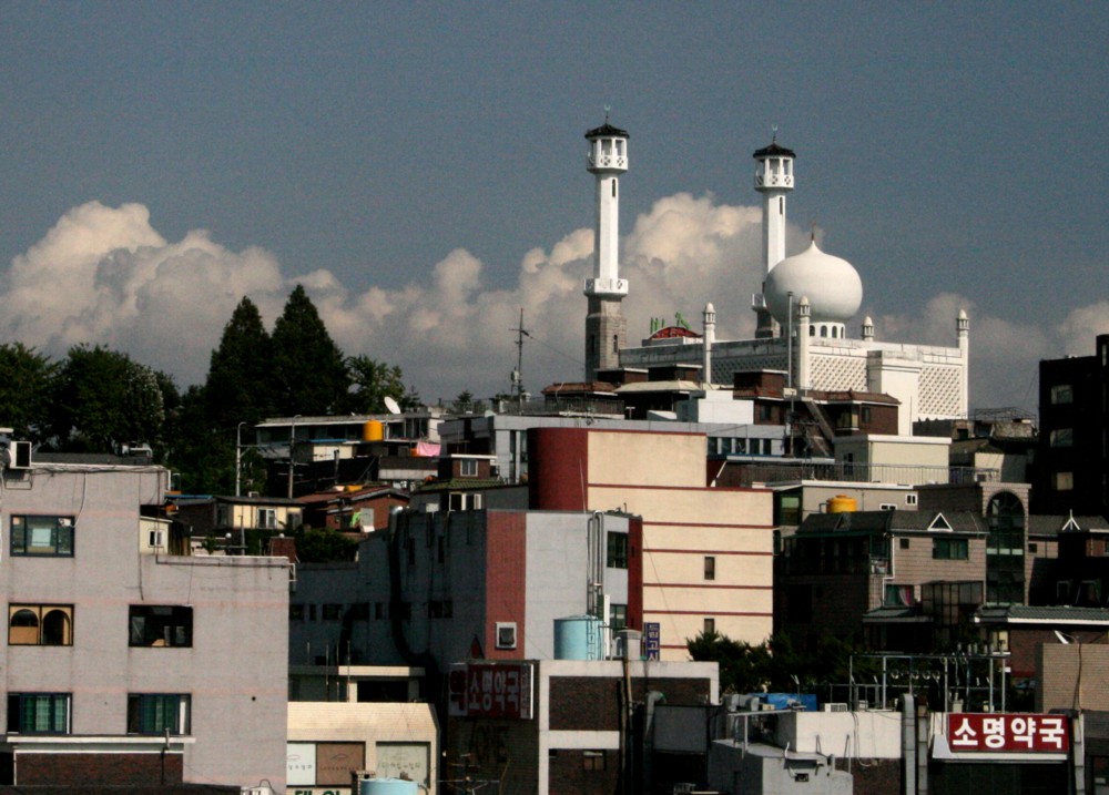 The white dome and twin minarets of Seoul Central Mosque rising above Itaewon rooftops