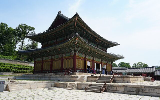 Two-storey Injeongjeon throne hall at Changdeokgung Palace with stone terraces and wooded hill behind