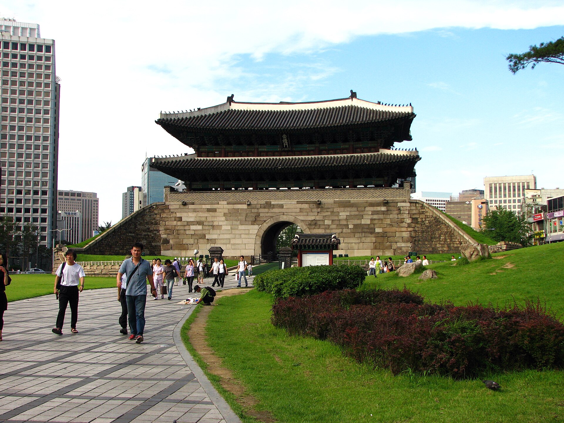 Sungnyemun, Seoul's great south gate, with a stone base and two-tiered wooden pavilion surrounded by lawns and office towers