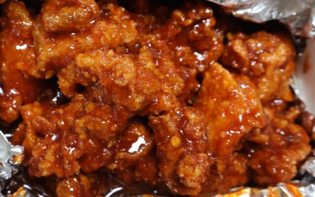 Close-up of Korean fried chicken pieces coated in glossy red yangnyeom sauce